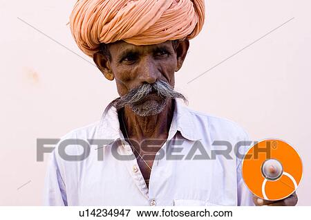 Stock Photo - Mature man holding a cd, Pushkar, Rajasthan, India. Fotosearch