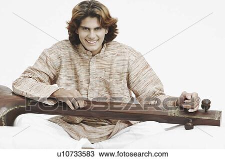 Portrait of a male musician holding a sitar View Large Photo Image Stock Image - Portrait of a male musician holding a sitar. Fotosearch