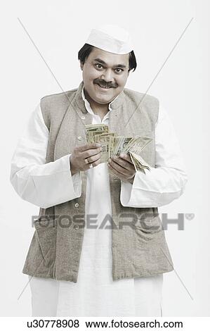 Portrait of a male politician counting Indian currency View Large Photo Image Stock Photo - Portrait of a male politician counting Indian currency. Fotosearch