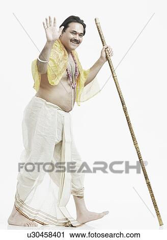 Stock Image - Portrait of a priest holding a stick. Fotosearch