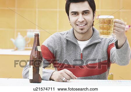 Portrait of a young man holding a beer stein View Large Photo Image Stock Image - Portrait of a young man holding a beer stein. Fotosearch