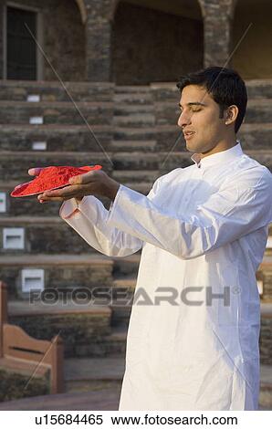 Side profile of a young man holding a plate of powder paint View Large Photo Image Stock Photography - Side profile of a young man holding a plate of powder paint. Fotosearch