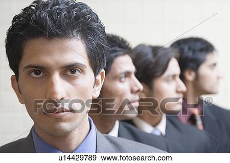 Stock Photo - Close-up of four businessmen looking serious. Fotosearch