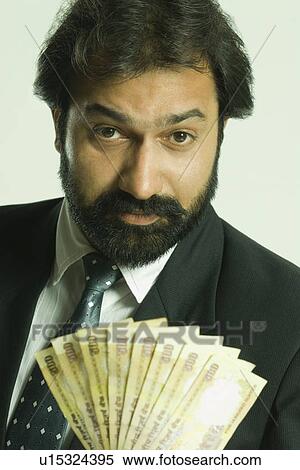 Portrait of a businessman holding Indian five hundred rupee notes View Large Photo Image Stock Photography - Portrait of a businessman holding Indian five hundred rupee notes. Fotosearch