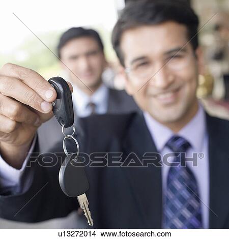Portrait of a businessman showing a key and smiling View Large Photo Image Picture - Portrait of a businessman showing a key and smiling. Fotosearch