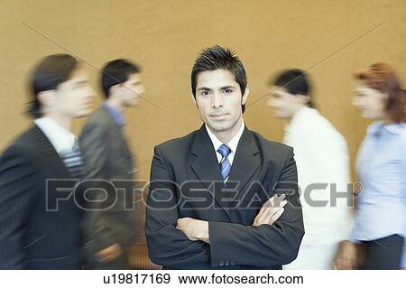 Stock Photo - Portrait of a businessman standing with his arms crossed. Fotosearch