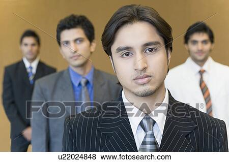 Portrait of a businessman with three business executives standing behind him View Large Photo Image Stock Photo - Portrait of a businessman with three business executives standing behind him. Fotosearch