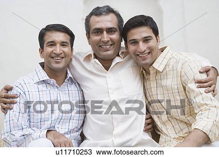 Portrait of two mid adult men and a young man smiling View Large Photo Image Stock Image - Portrait of two mid adult men and a young man smiling. Fotosearch