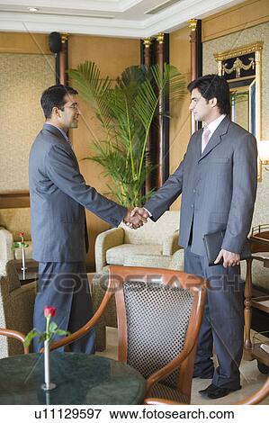 Side profile of two businessmen shaking hands View Large Photo Image Stock Photo - Side profile of two businessmen shaking hands. Fotosearch