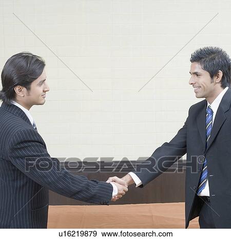 Two businessmen shaking hands and smiling View Large Photo Image Stock Photo - Two businessmen shaking hands and smiling. Fotosearch