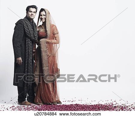 Portrait of a newlywed couple standing on rose petals View Large Photo Image Picture - Portrait of a newlywed couple standing on rose petals. Fotosearch