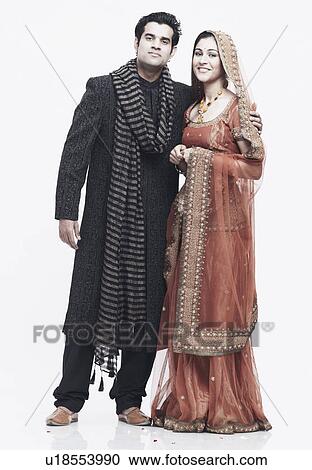 Portrait of a newlywed couple standing with their arms around each other View Large Photo Image Stock Image - Portrait of a newlywed couple standing with their arms around each other. Fotosearch