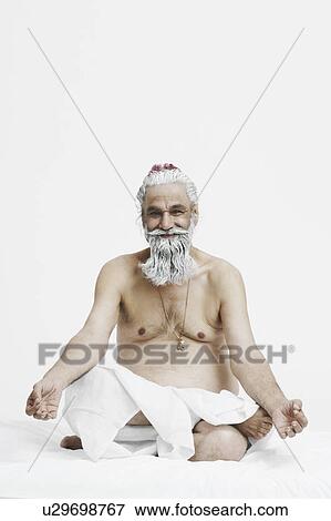 Stock Photo - Portrait of a priest sitting in the lotus position. Fotosearch