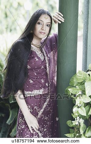 Picture - Portrait of a teenage girl in a traditional dress leaning against a column. Fotosearch