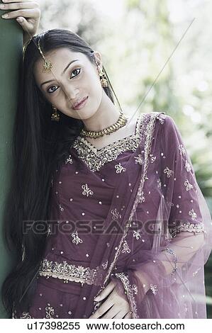 Stock Photography - Portrait of a teenage girl in a traditional dress leaning against a column. Fotosearch