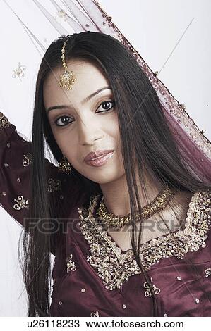 Stock Image - Portrait of a teenage girl posing in a traditional dress. Fotosearch