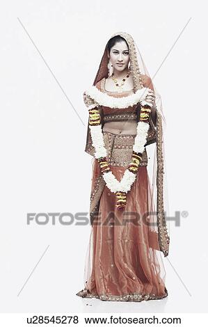 Portrait of a young woman in traditional clothing holding a garland View Large Photo Image Stock Photo - Portrait of a young woman in traditional clothing holding a garland. Fotosearch