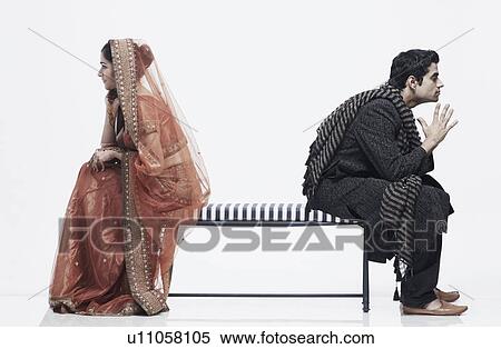 Side profile of a newlywed couple sitting on opposite ends of a bench View Large Photo Image Stock Photography - Side profile of a newlywed couple sitting on opposite ends of a bench. Fotosearch