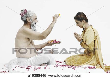Stock Photograph - Side profile of a priest blessing a young woman. Fotosearch