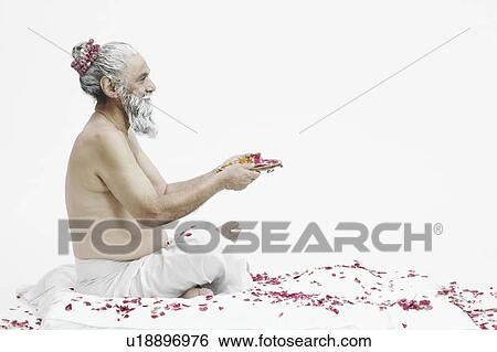 Stock Photograph - Side profile of a priest holding a religious offering. Fotosearch