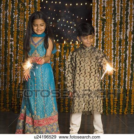 Boy and his sister holding sparklers View Large Photo Image Stock Photo - Boy and his sister holding sparklers. Fotosearch