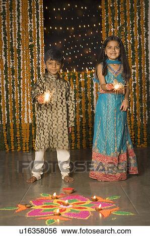 Stock Photograph - Boy and his sister holding sparklers. Fotosearch