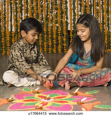 Stock Photography - Boy and his sister making rangoli. Fotosearch