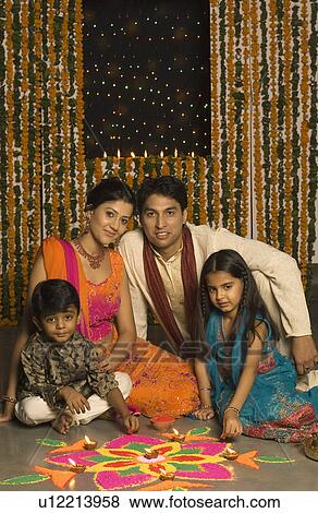 Portrait of a young couple with their son and daughter sitting behind a rangoli View Large Photo Image Stock Photo - Portrait of a young couple with their son and daughter sitting behind a rangoli. Fotosearch
