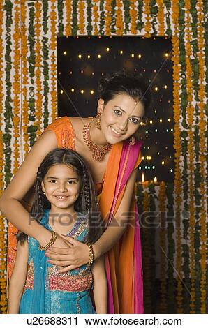 Portrait of a young woman standing with her daughter View Large Photo Image Stock Image - Portrait of a young woman standing with her daughter. Fotosearch