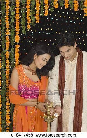 Young couple lighting a lamp View Large Photo Image Stock Photo - Young couple lighting a lamp. Fotosearch