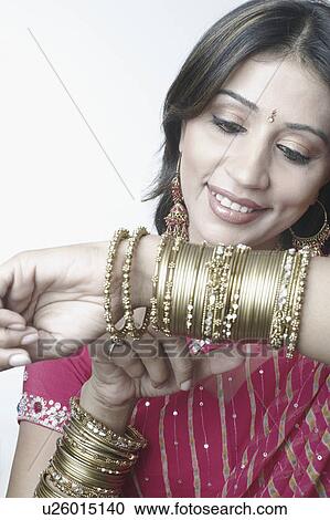 Close-up of a mid adult woman looking at her bangles View Large Photo Image Stock Image - Close-up of a mid adult woman looking at her bangles. Fotosearch