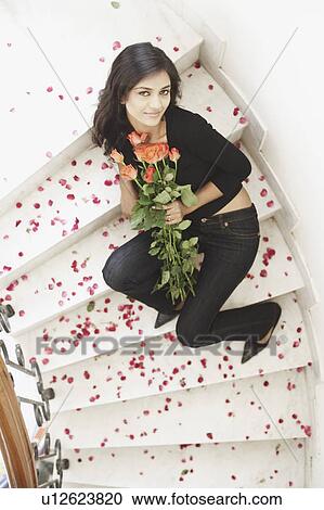 High angle view of a young woman holding a bouquet of flowers View Large Photo Image Stock Image - High angle view of a young woman holding a bouquet of flowers. Fotosearch