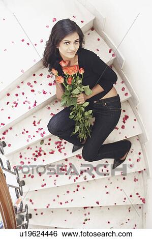 High angle view of a young woman holding a bouquet of flowers View Large Photo Image Stock Photograph - High angle view of a young woman holding a bouquet of flowers. Fotosearch