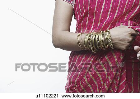 Mid section view of a woman wearing bangles View Large Photo Image Stock Image - Mid section view of a woman wearing bangles. Fotosearch