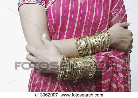 Mid section view of a woman wearing bangles View Large Photo Image Stock Photo - Mid section view of a woman wearing bangles. Fotosearch