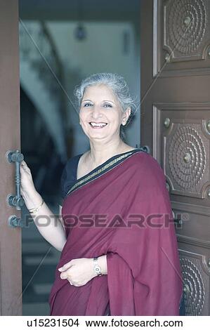 Picture - Portrait of a mature woman standing at a doorway. Fotosearch