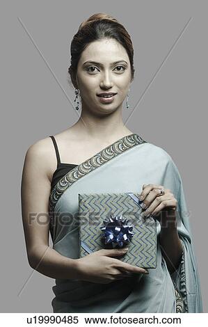 Stock Photography - Portrait of a young woman holding a gift. Fotosearch