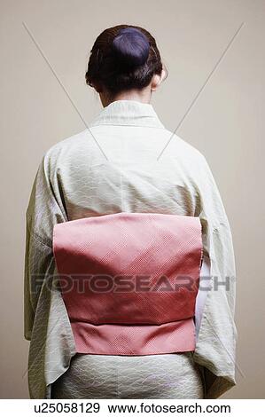 Rear view of a young woman wearing a kimono View Large Photo Image Stock Photo - Rear view of a young woman wearing a kimono. Fotosearch