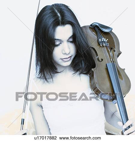 Stock Image - Close-up of a young woman holding a violin. Fotosearch