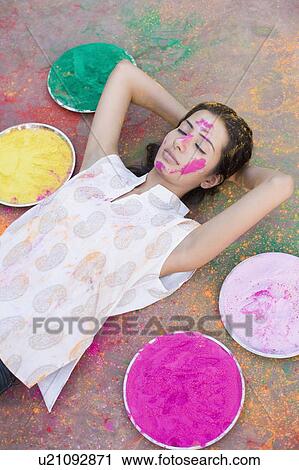 High angle view of a young woman lying on the floor with powder paint on her face View Large Photo Image Stock Image - High angle view of a young woman lying on the floor with powder paint on her face. Fotosearch