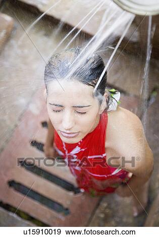 Stock Photo - High angle view of a young woman taking a shower. Fotosearch