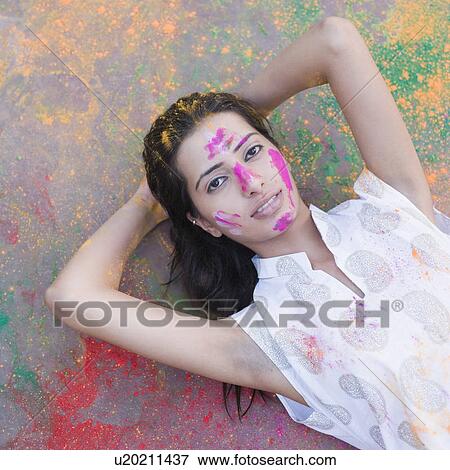 Portrait of a young woman lying on the floor with powder paint on her face View Large Photo Image Stock Photo - Portrait of a young woman lying on the floor with powder paint on her face. Fotosearch