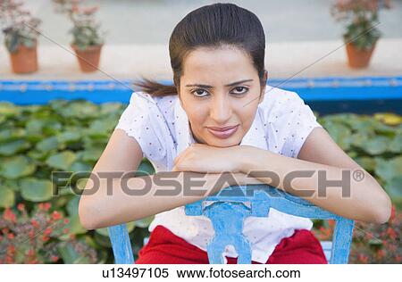 Stock Photography - Portrait of a young woman resting her chin on her hands. Fotosearch