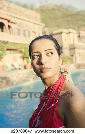 Stock Photo - Side profile of a young woman at the poolside. Fotosearch