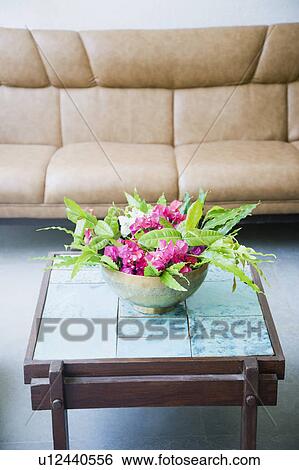 Stock Photograph - Close-up of a bowl of flowers on a table in a living room. Fotosearch