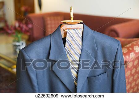 Stock Photo - Close-up of a business suit and a tie hanging on a hanger. Fotosearch