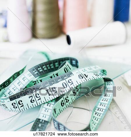 Picture - Close-up of a tape measure with spools of thread. Fotosearch