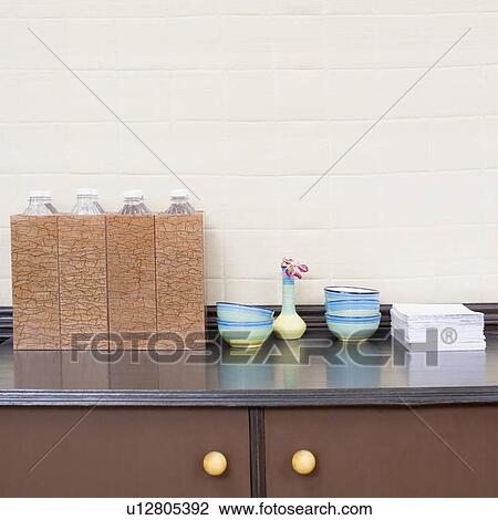 Close-up of stacks of bowls and a vase with bottles on a cabinet View Large Photo Image Stock Image - Close-up of stacks of bowls and a vase with bottles on a cabinet. Fotosearch