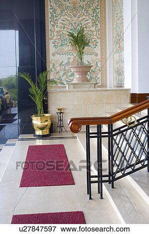 Doormats and potted plants in front of a staircase View Large Photo Image Stock Photo - Doormats and potted plants in front of a staircase. Fotosearch