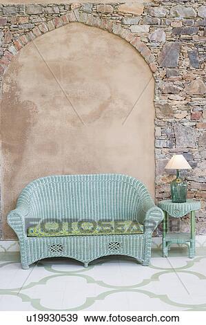 Empty couch and a lamp shade on a side table in front of a wall View Large Photo Image Stock Photo - Empty couch and a lamp shade on a side table in front of a wall. Fotosearch